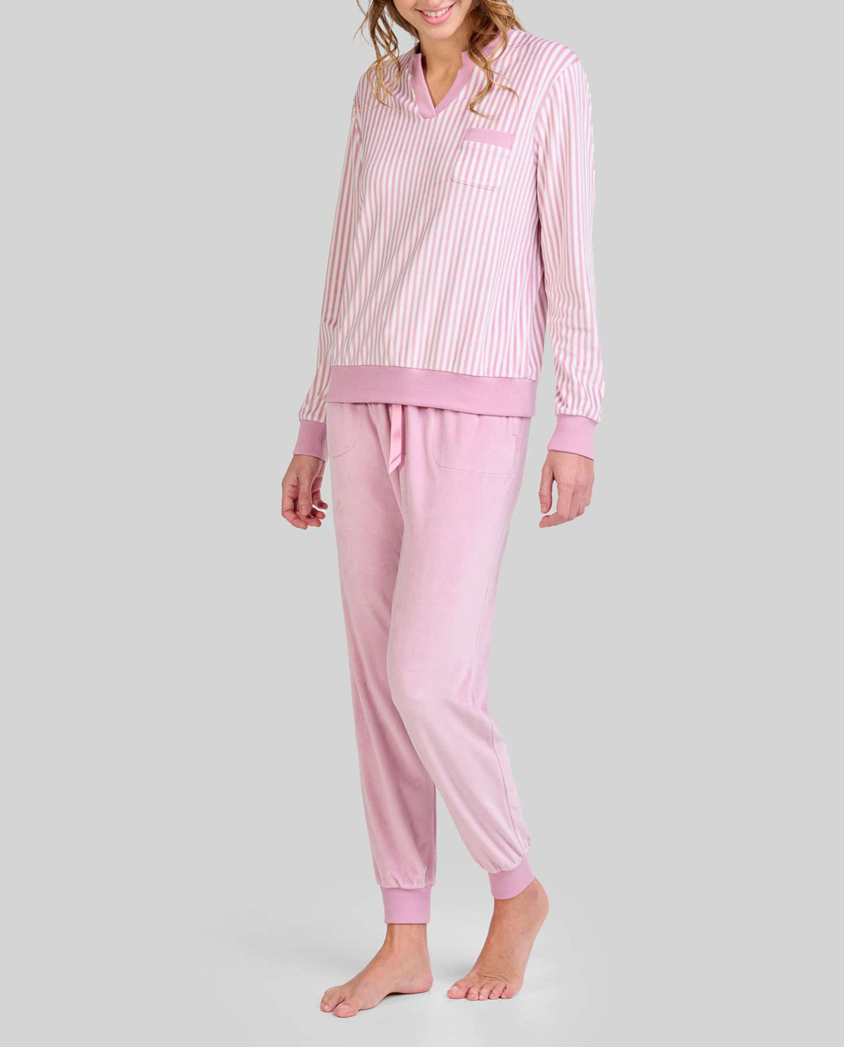 Mujer con pijama de invierno en suave tejido micropolar de rayas con escote y aberturas elásticas, manga larga y pantalón largo.