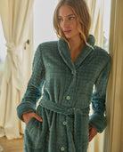 Modelo posa con amorosa bata larga de invierno jacquard verde