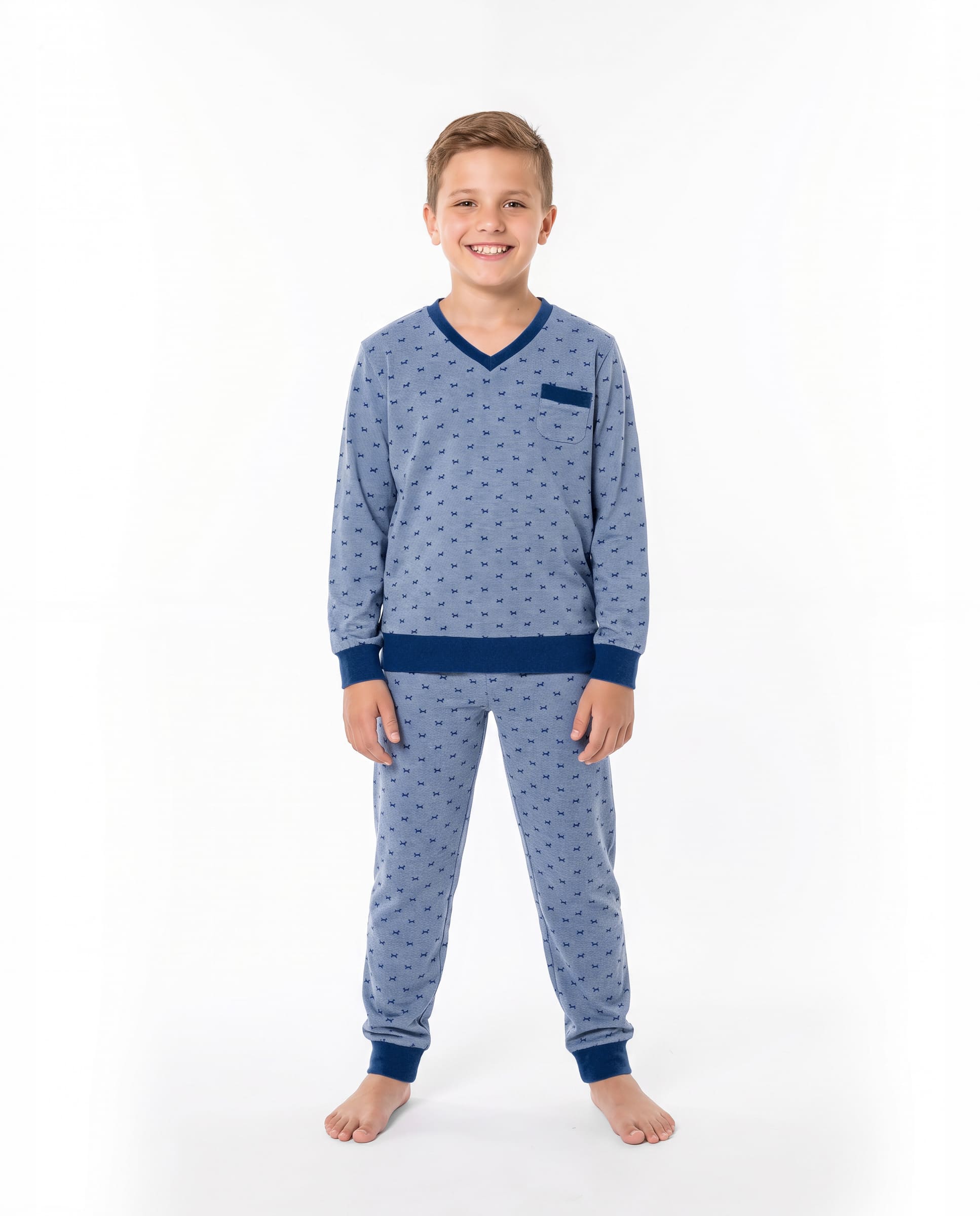 Un niño posa luciendo un pijama de invierno decorado con divertidos perritos.