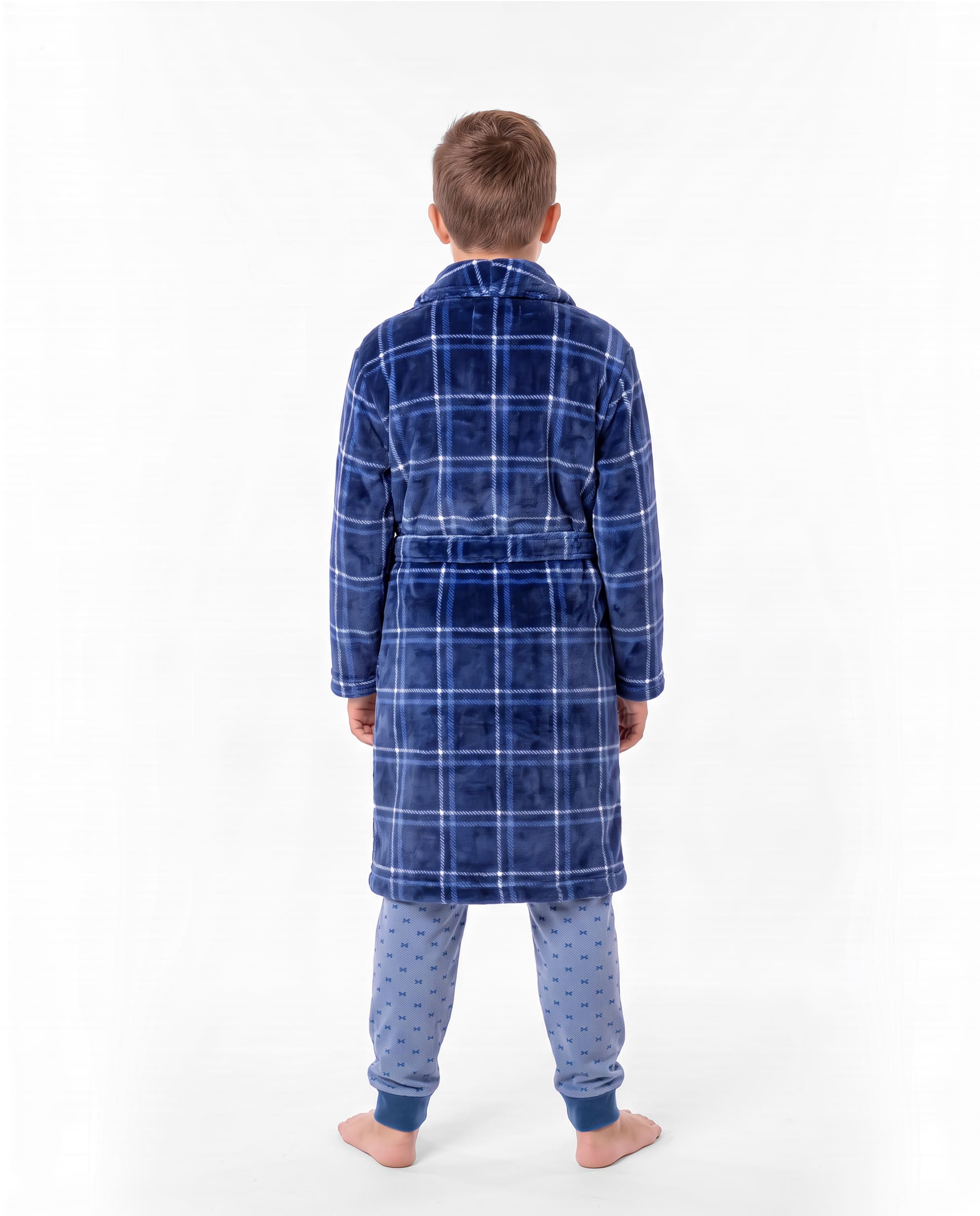 Niño de espaldas con bata de invierno de cuadros azules con cinturón sobre un pijama azul claro