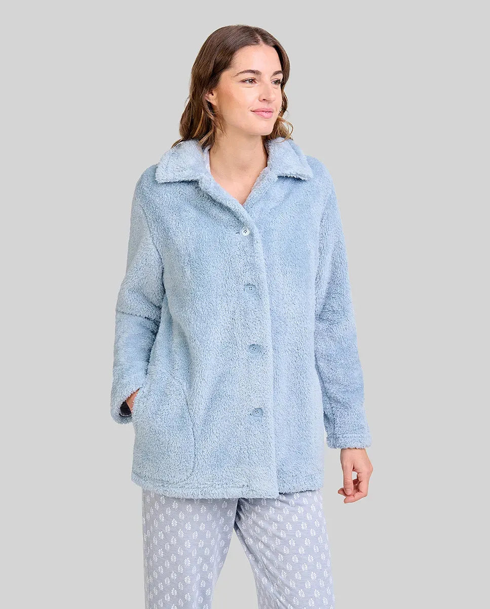 Mujer luce cómoda y actual bata corta de rizo azul acero abotonada con bolsillos