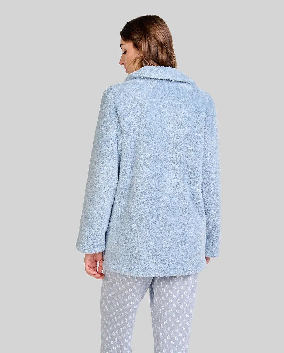 Mujer de espaldas con bata cálida de rizo azul claro ideal para invierno