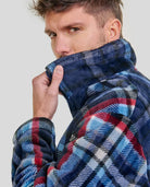 Hombre sujetando el cuello de su agradable bata polar corta de cuadros para invierno