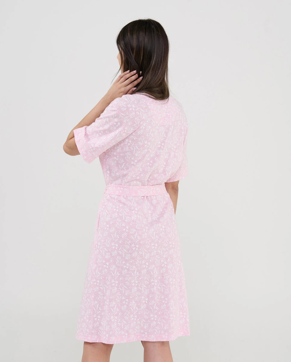 Vista trasera de mujer con bata rosa y estampado florecitas blancas