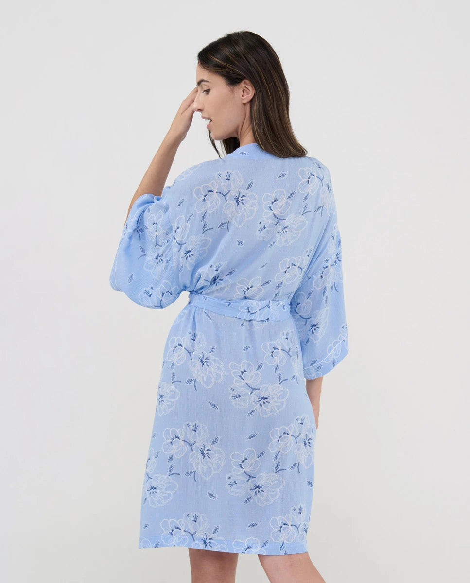 Vista de espaldas de mujer con bata cruzada celeste para verano