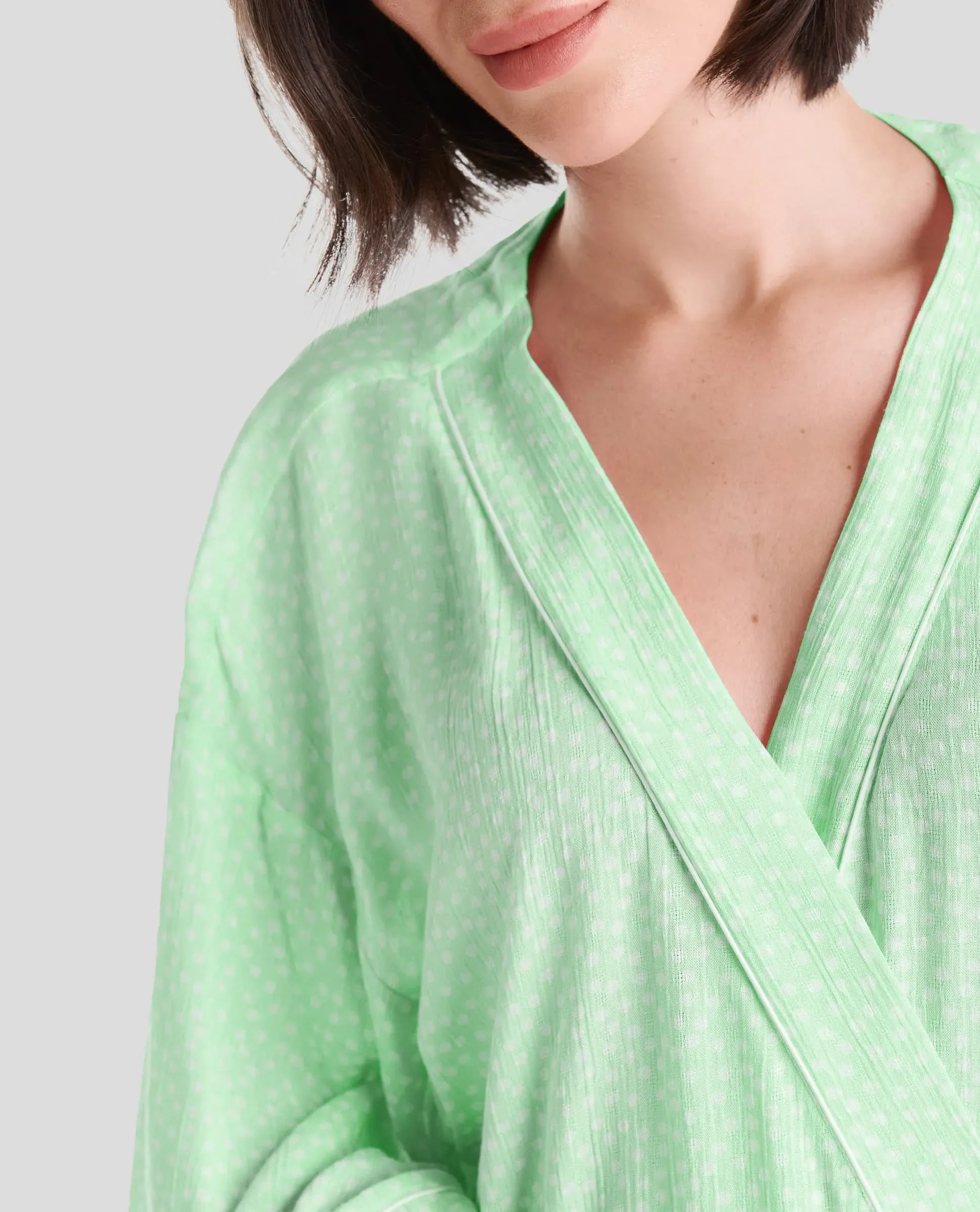 Detalle del escote cruzado gris con tira de cuello con vivo de raso plateado - Verde