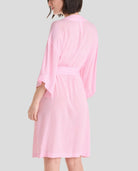 Mujer de espaldas luce elegante bata de verano con manga francesa en color rosa a topitos, con cinturón y bolsillos laterales - Rosa