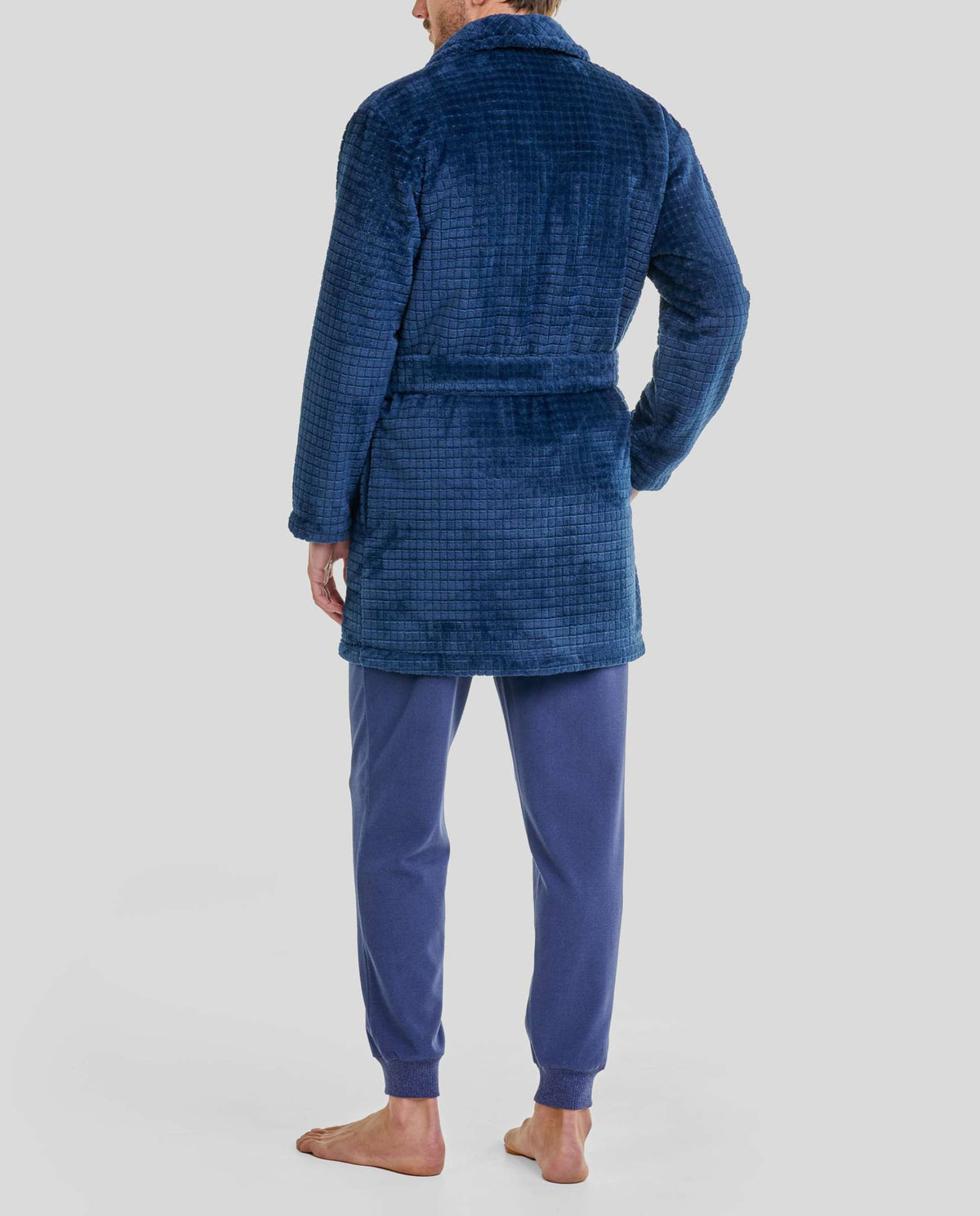Hombre  de espaldas con bata corta azul marino de bolsillos y pijama azul