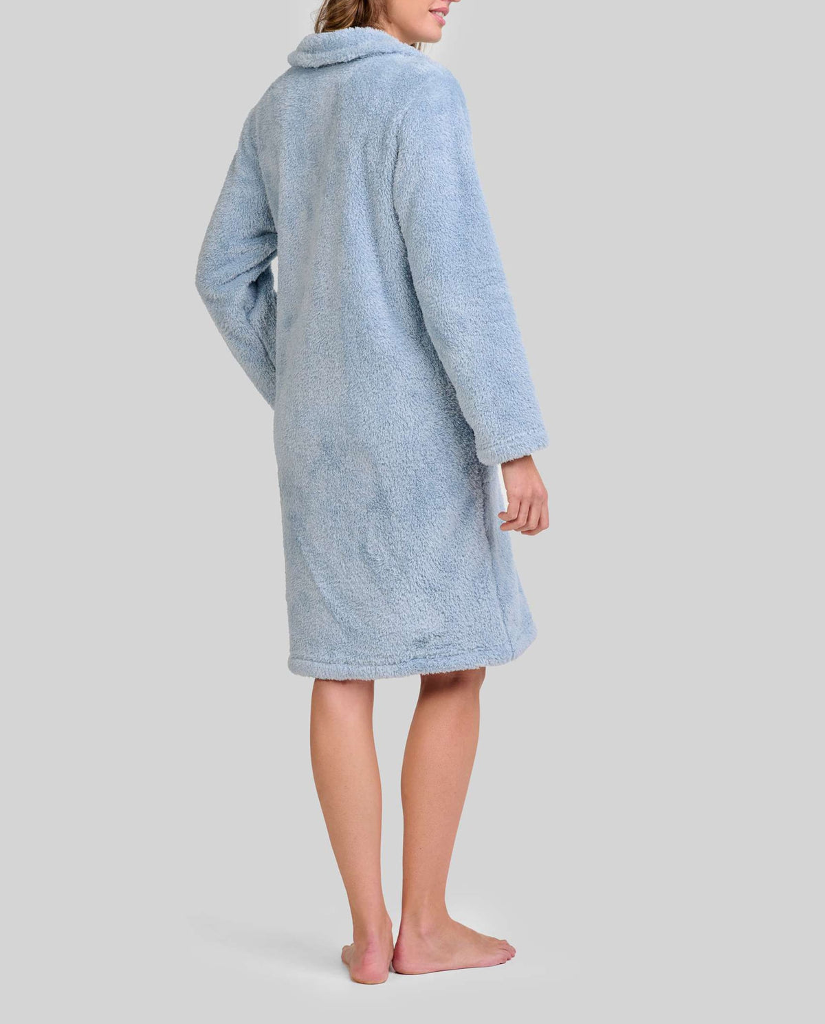 Mujer de espaldas con bata polar azul acero de manga larga y hasta la rodilla