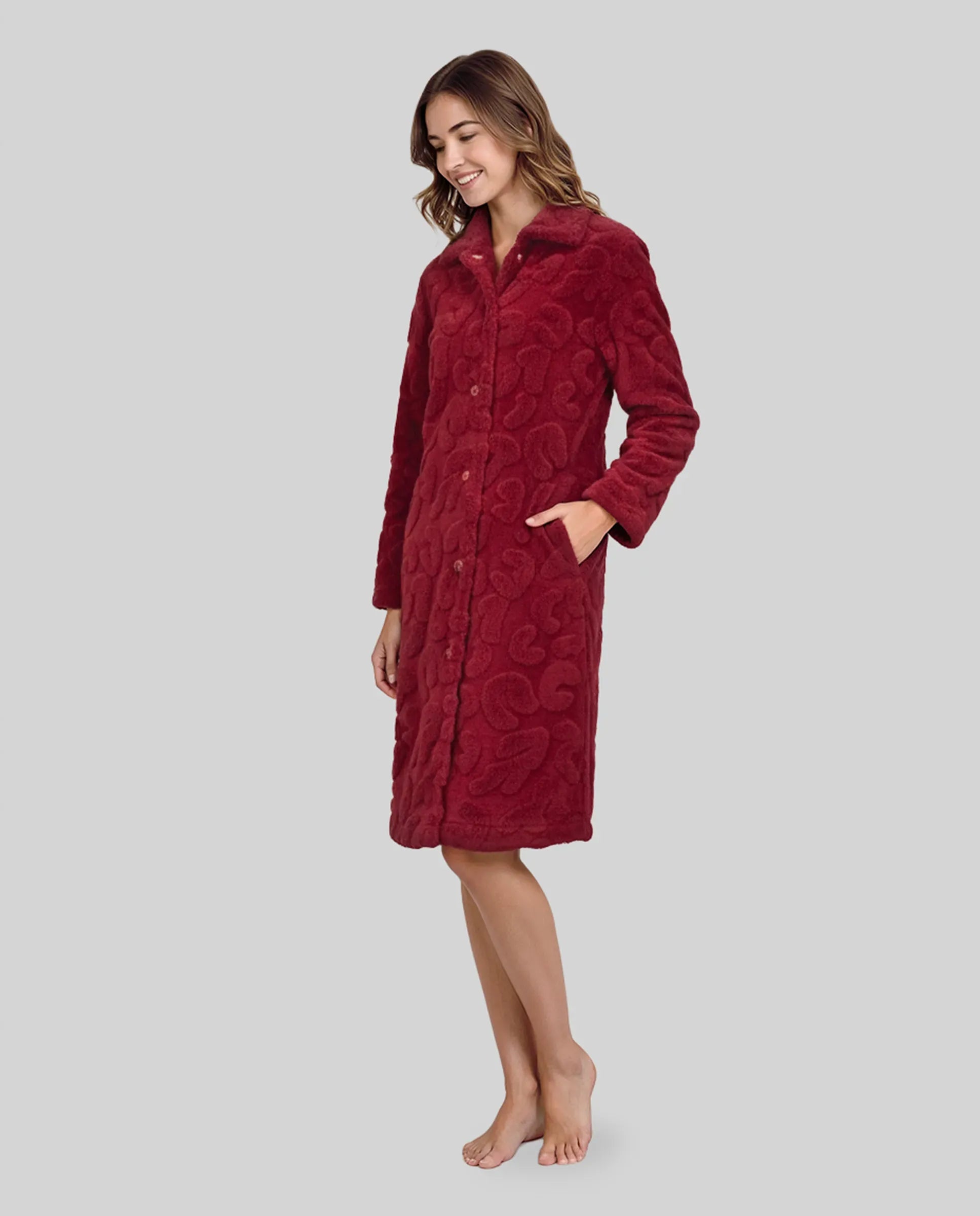 Mujer con bata larga de invierno abotonada y con bolsillos en amoroso tejido jacquard granate