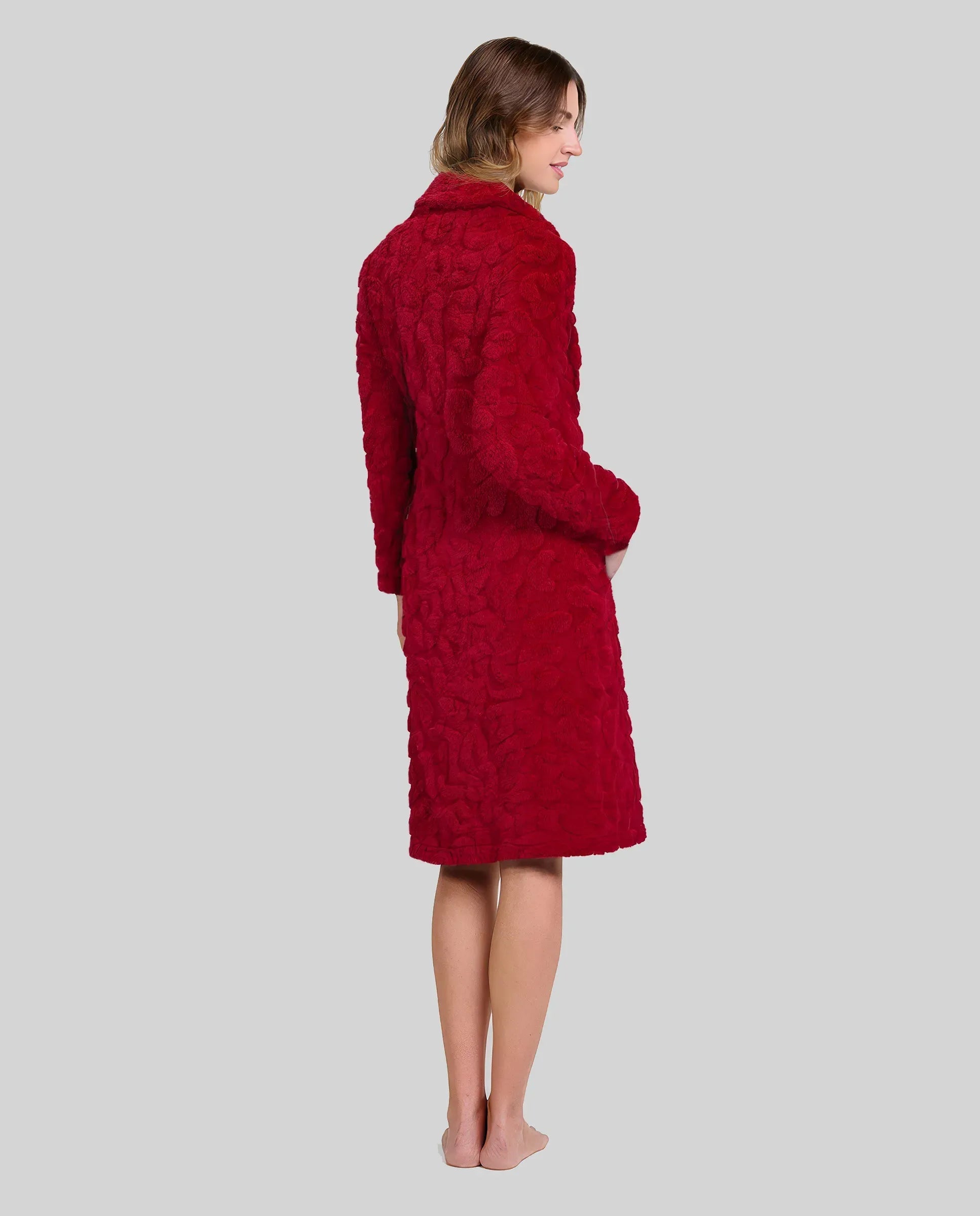Mujer de espaldas luce bata abotonada y con bolsillos en jacquard granate para el invierno