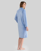 Mujer de espaldas luce bata larga de invierno jacquard azul con bolsillos