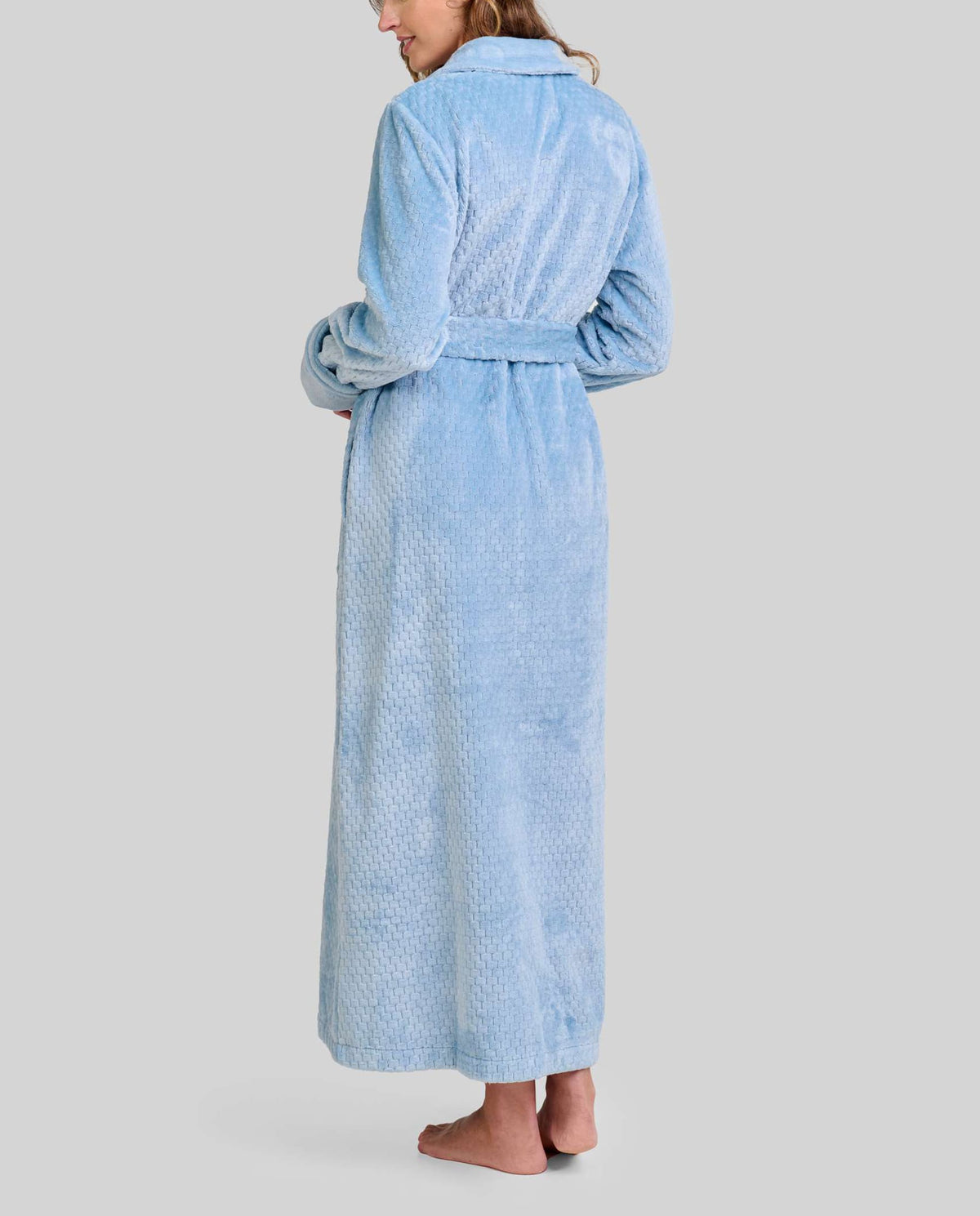 Mujer de espaldas con bata de invierno hasta los pies en clásico Jacquard azul acero con cinturón