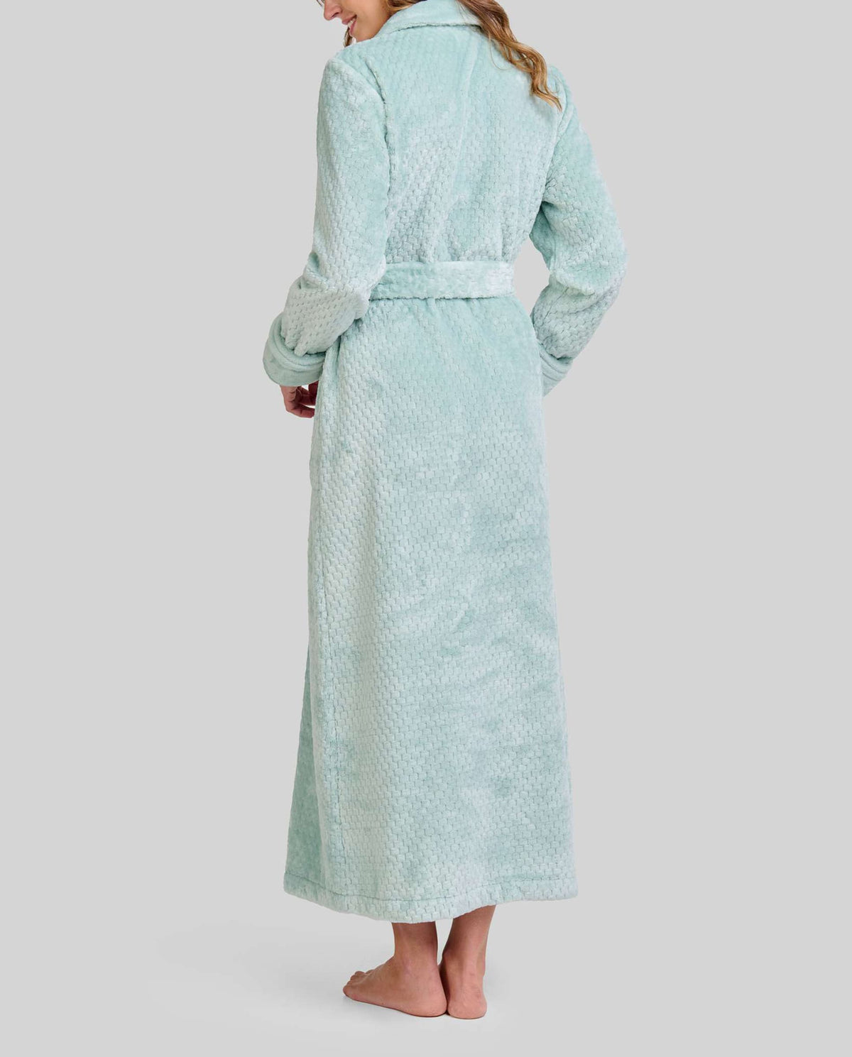Mujer de espaldas con bata de invierno hasta los pies en clásico Jacquard verde suave con cinturón