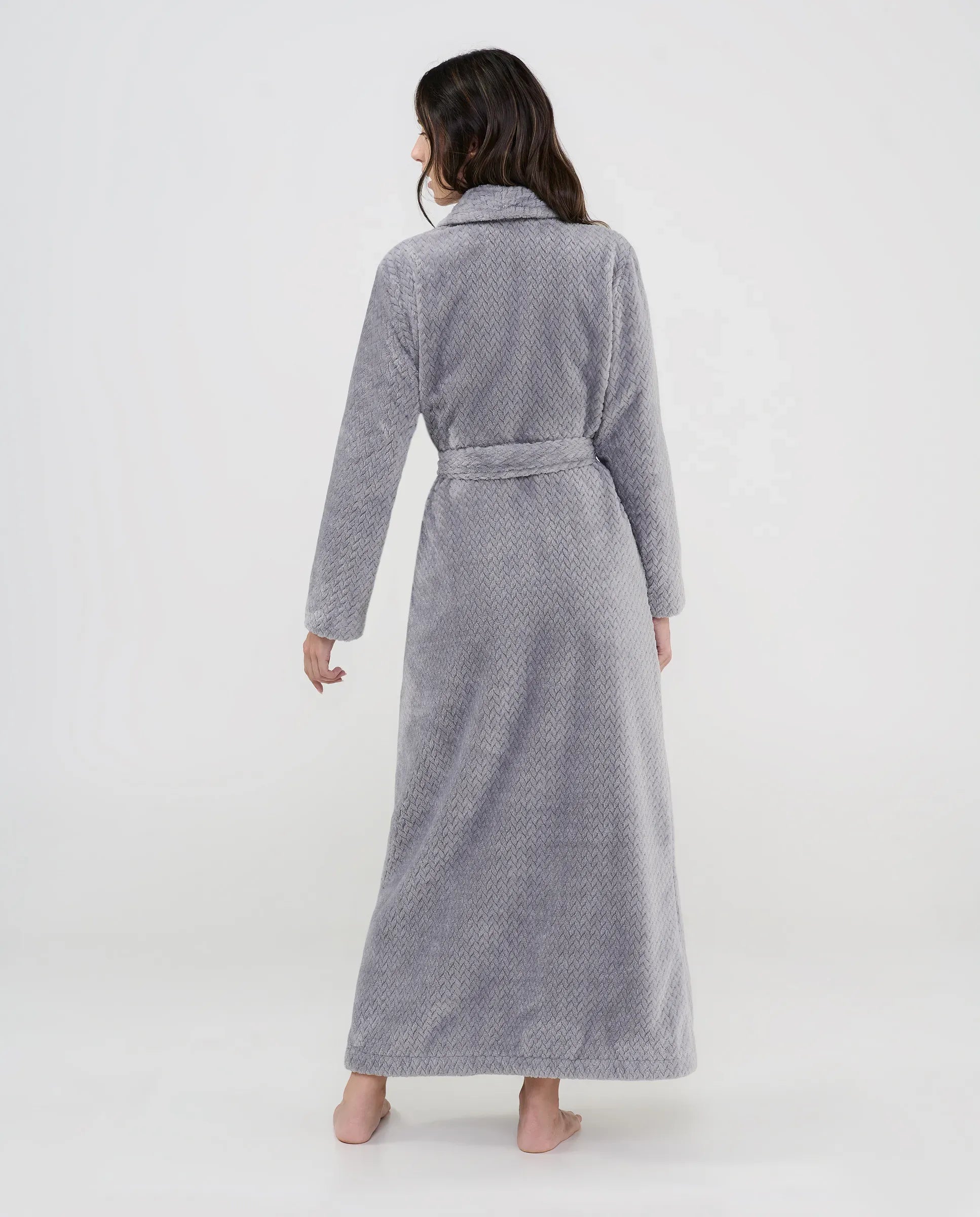 Mujer de espaldas con bata larga gris textura espiga con cinturón ideal para hogar.
