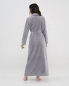 Mujer de espaldas con bata larga gris textura espiga con cinturón ideal para hogar.