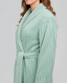 Vista lateral de mujer con bata larga de invierno abotonada jacquard verde