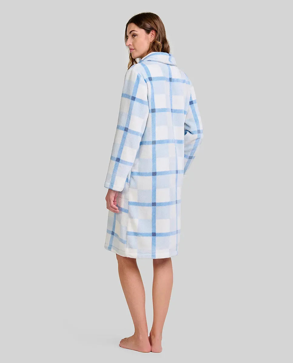 Mujer de espaldas, con bata larga hasta la rodilla azul y blanca a cuadros