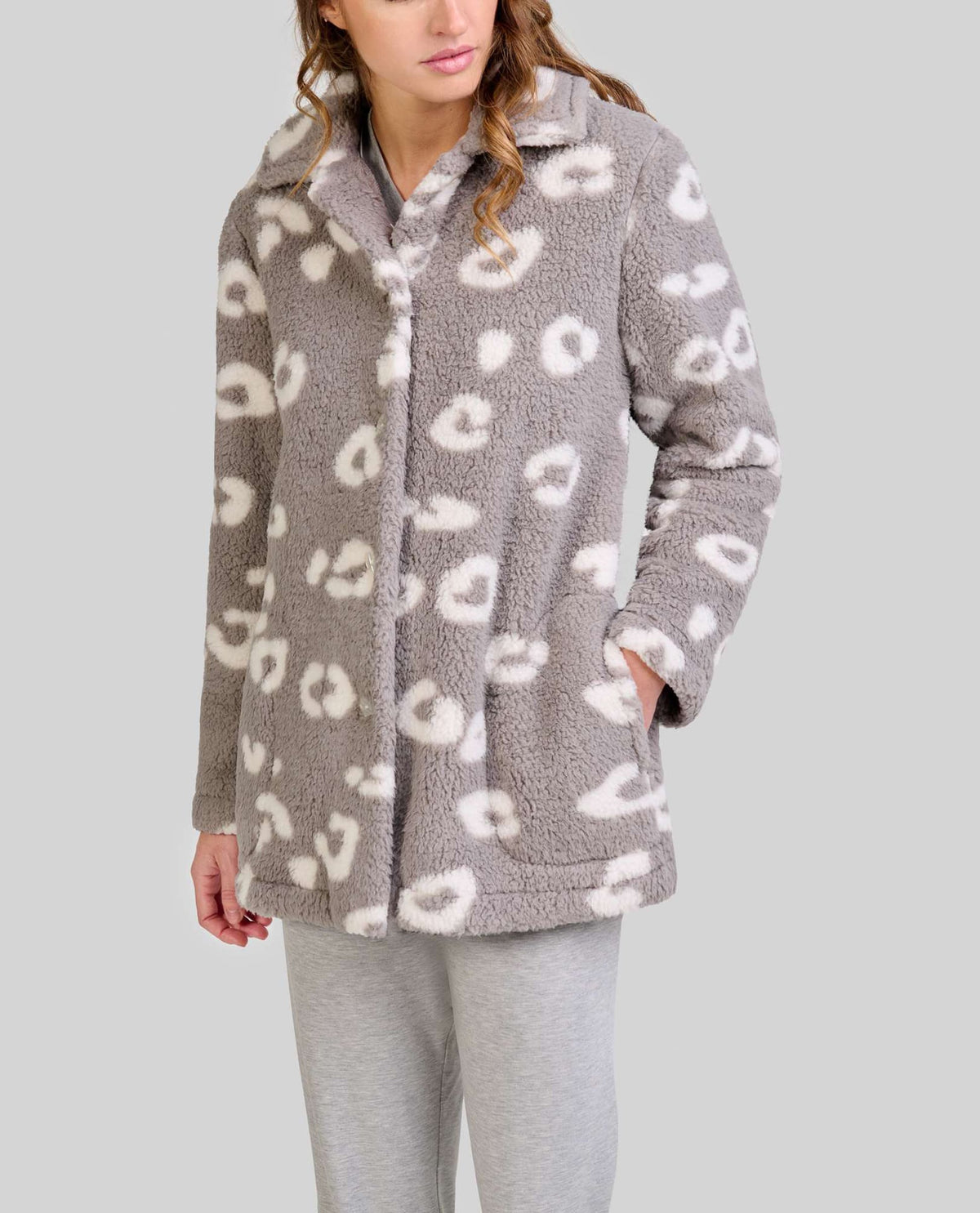 Mujer luce bata corta gris abotonada con estampado animal sobre pijama gris