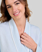 Detalle de cuello smoking con vivo de bata lencera celeste de mujer