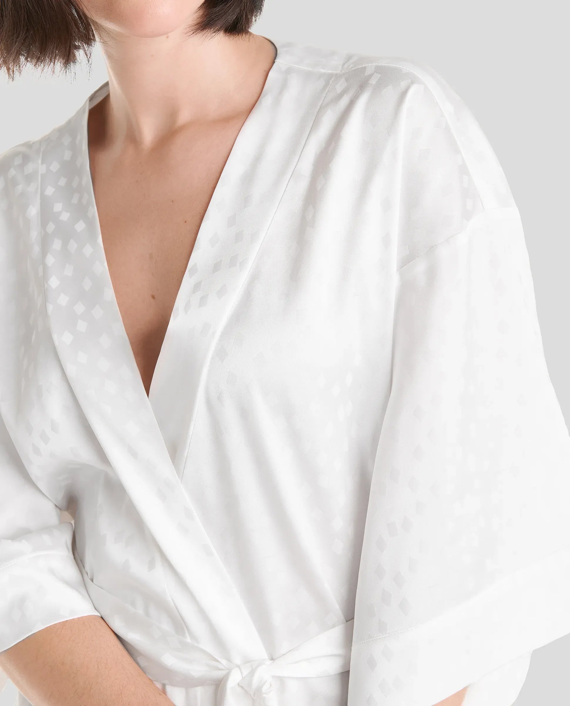 Detalle del cuello cruzado de elegante bata de verano jaquard marfil de Lohe