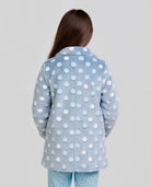 Vista lateral de niña posando con bata infantil de invierno estampada azul con círculos en relieve