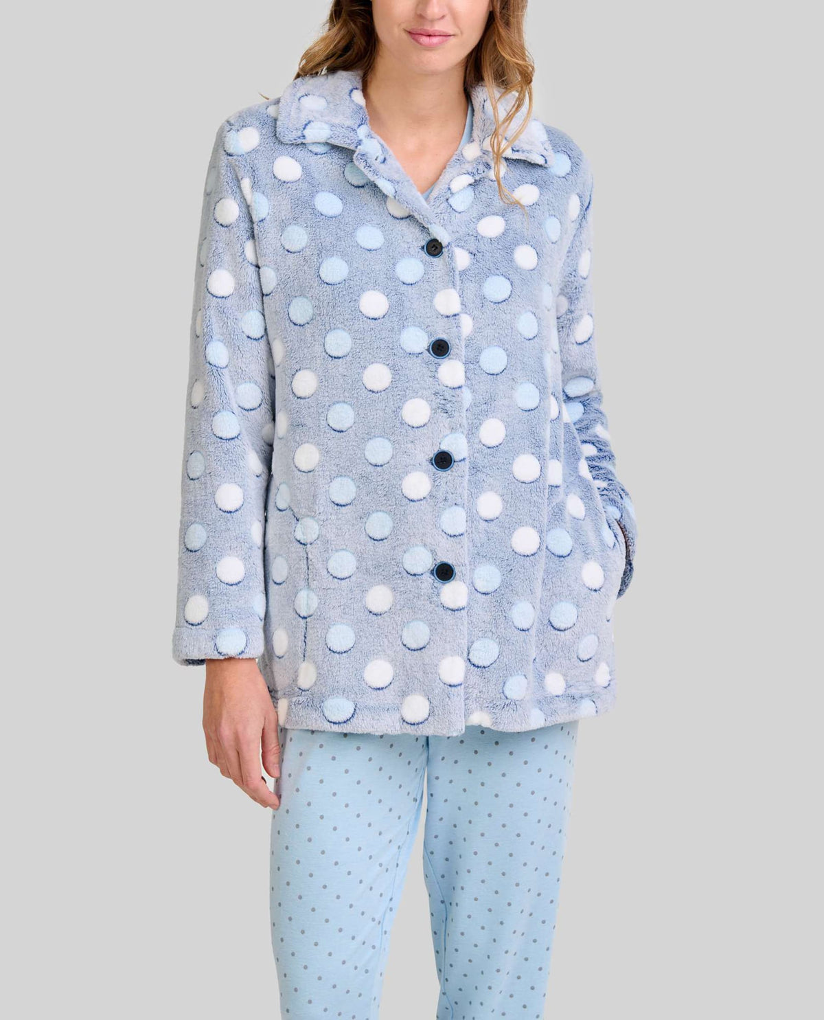 Mujer luce cómoda bata corta azul celeste con lunares y abertura de botones para invierno