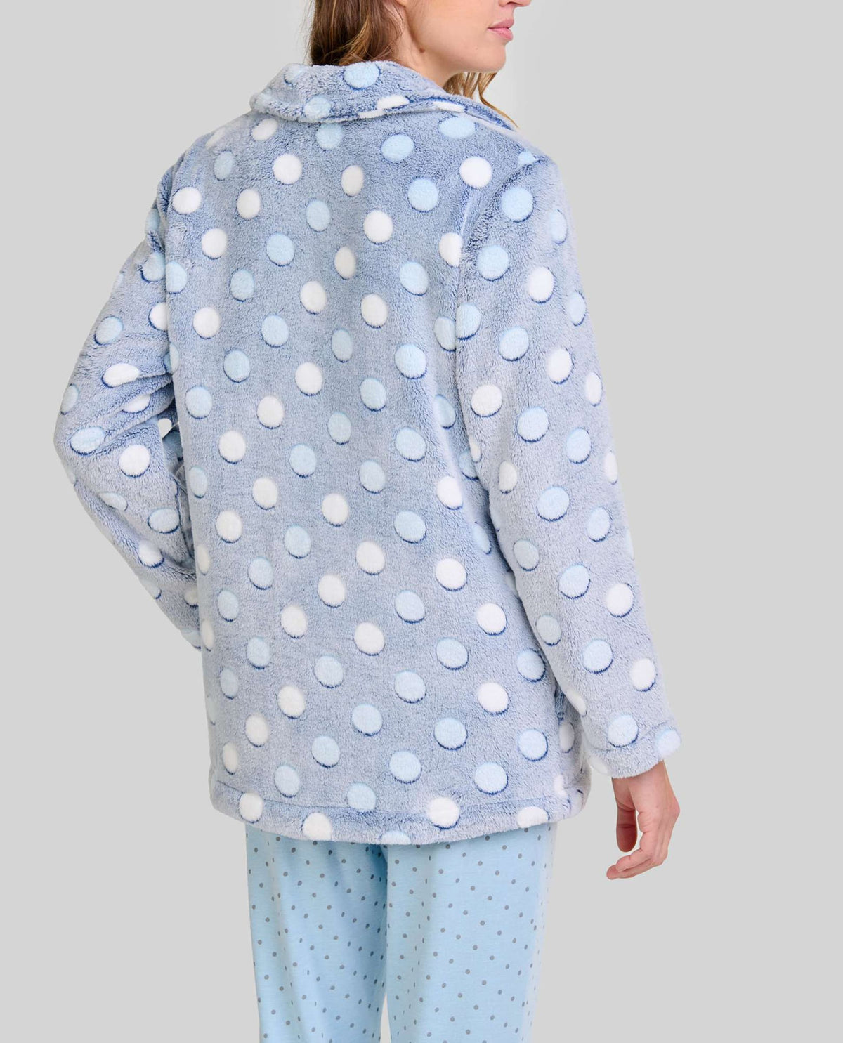 Mujer de espaldas con bata corta de estilo polar azul claro con lunares en relieve ideal para invierno en casa