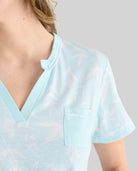 Detalle de cuello abierto de camisola de verano de manga corta verde estampada