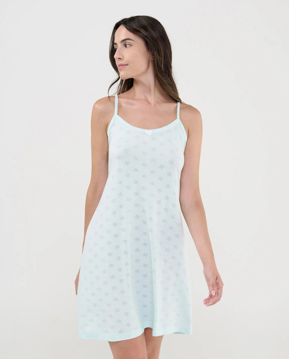 Mujer con camisón de verano de tirantes finos de punto verde y diseño desagujado de estrellitas