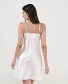 Mujer con camisón de tirantes finos en plana celeste a cuadros, escote pico plumeti con botones, lacito y puntilla.