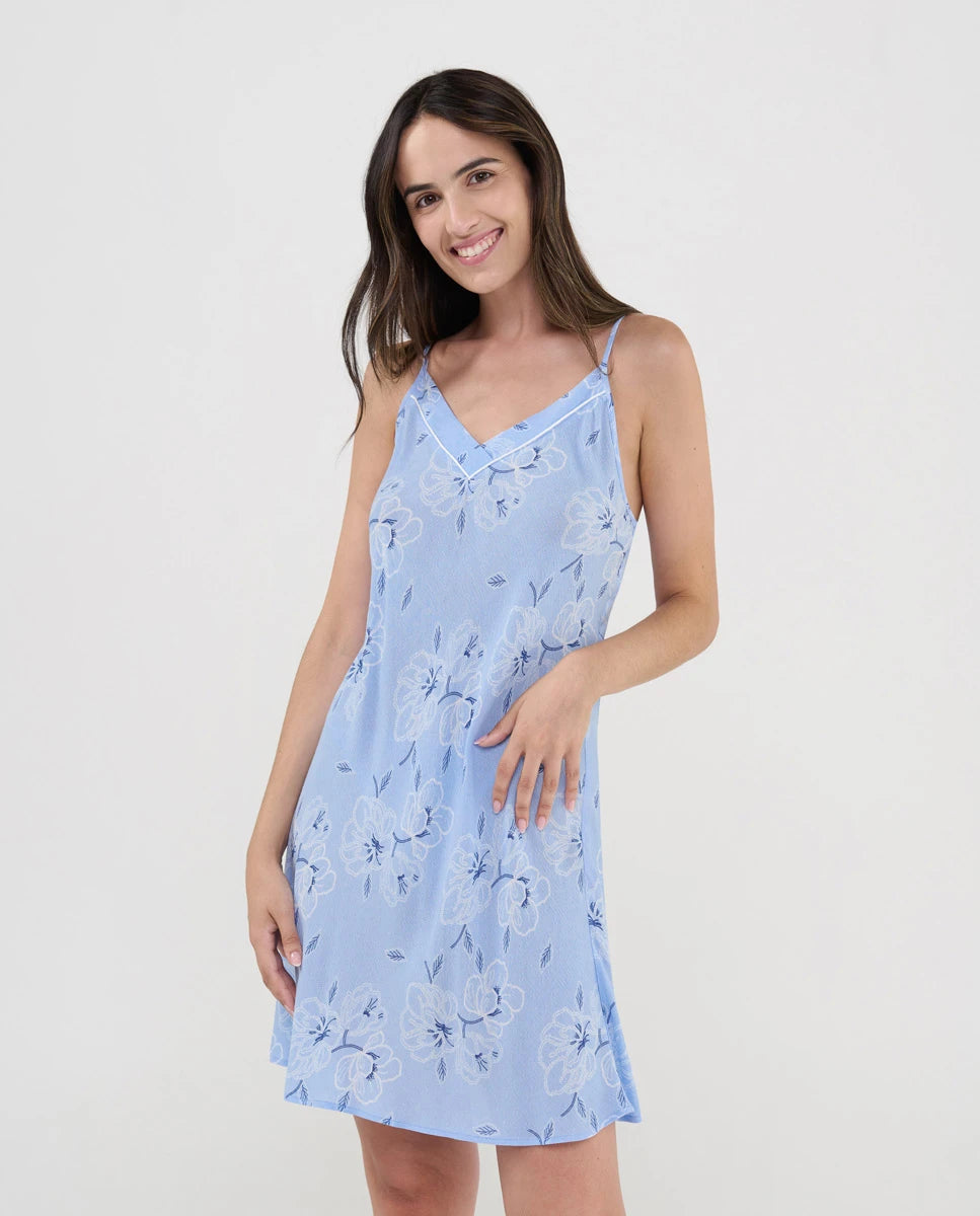 Mujer luce camisón corto de verano con tirantes finos estampado celeste de flores