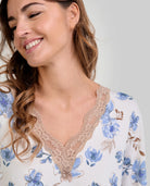 Mujer con camisón de flores azules y escote en V con encaje beige