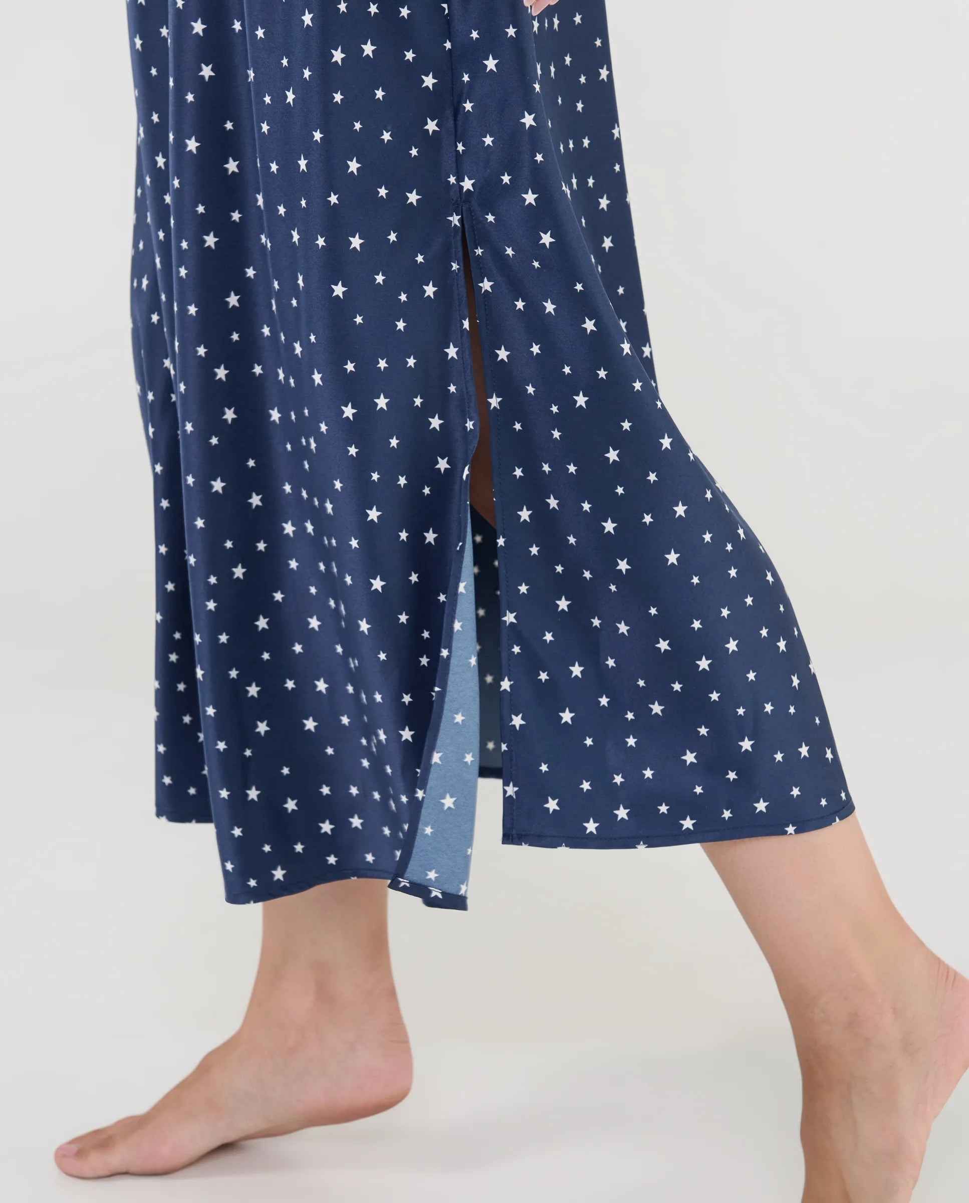 Primer plano del delicado tejido de raso con estampado de estrellas y finos tirantes regulables.