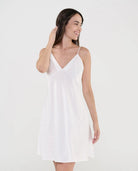 Mujer luce camisón lencero de suave tejido plana marfil con topos de raso, escote pico y tirantes