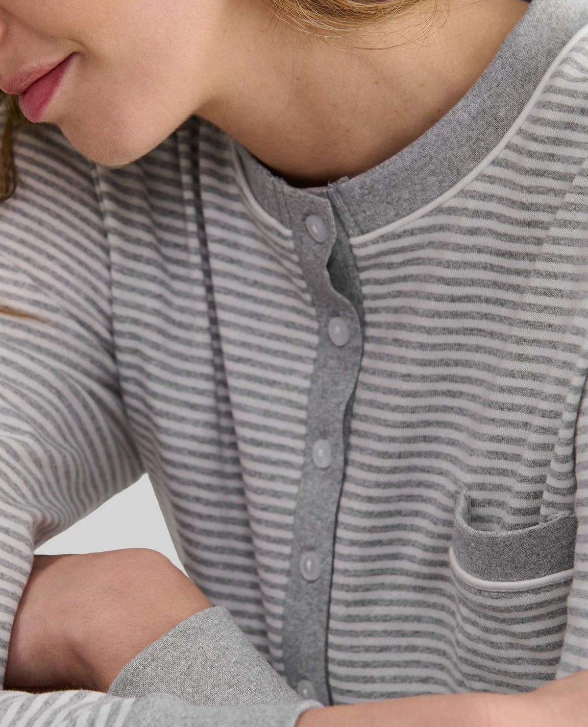 Detalle del cuello del camisón de invierno de manga larga a rayas grises con cuello redondo abotonado