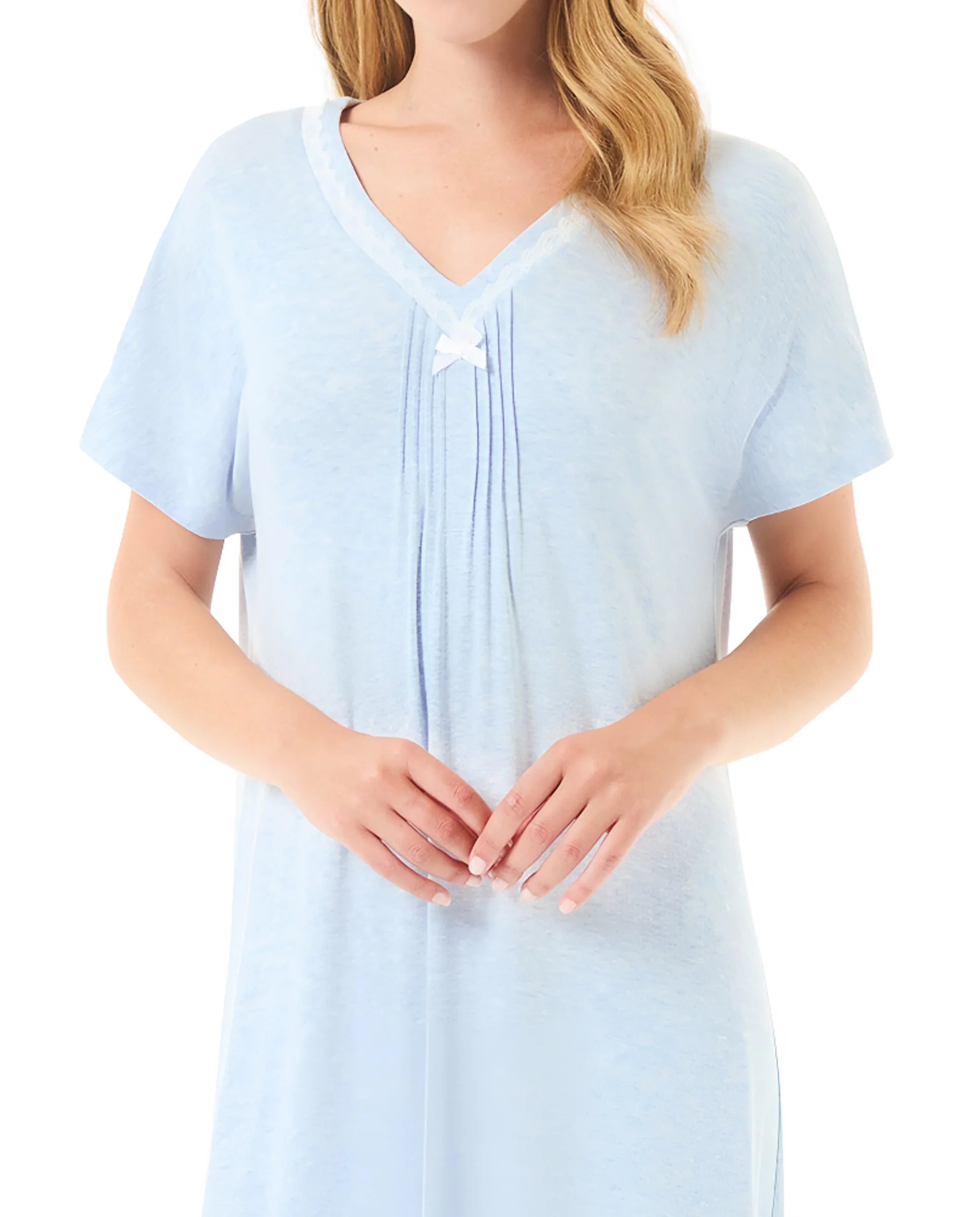 Mujer luciendo camisón azul celeste de manga corta con escote en V y detalles plisados con lazo