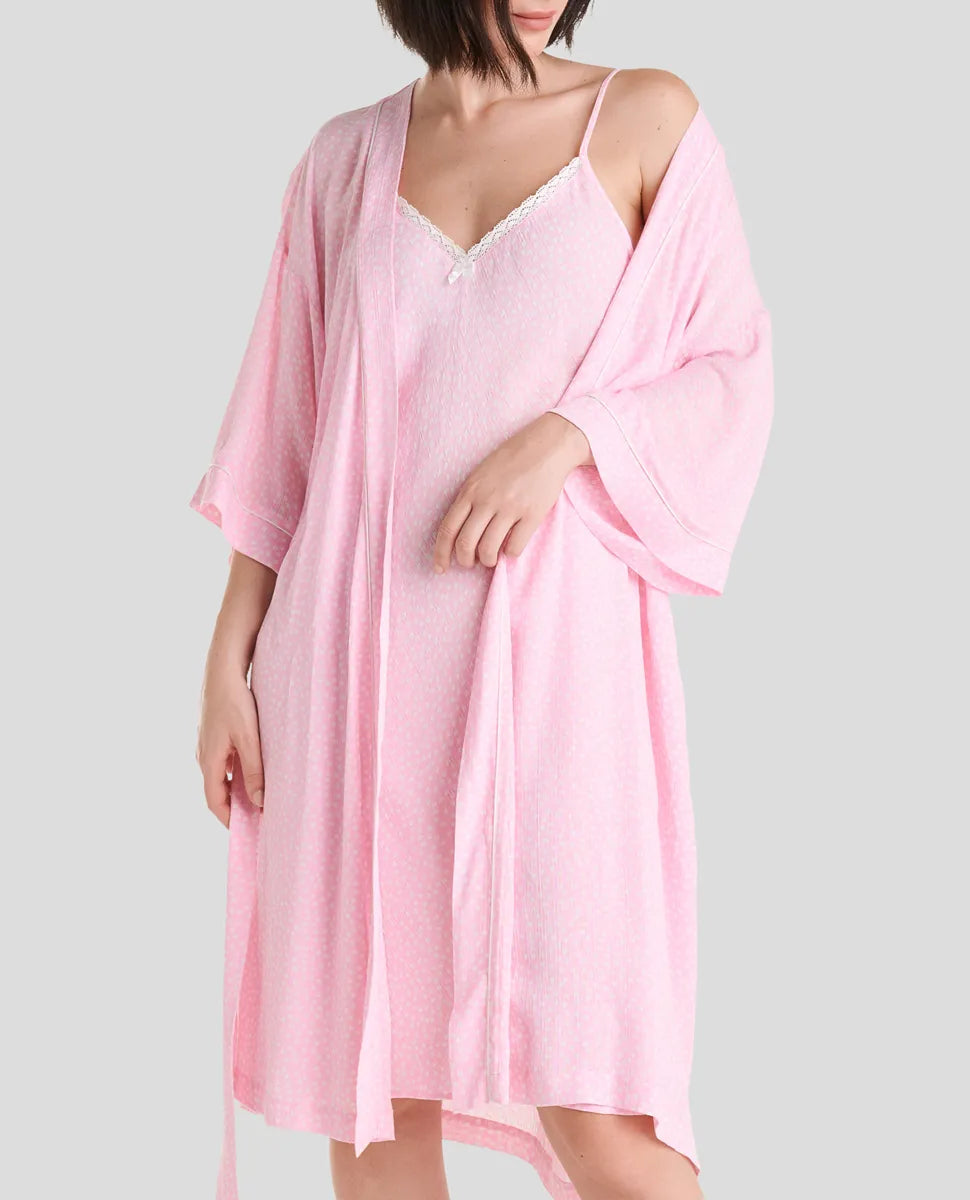 Mujer luce conjunto de verano compuesto por camisola rosa con ribete de encaje y bata a juego.