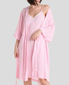Mujer luce conjunto de verano compuesto por camisola rosa con ribete de encaje y bata a juego.