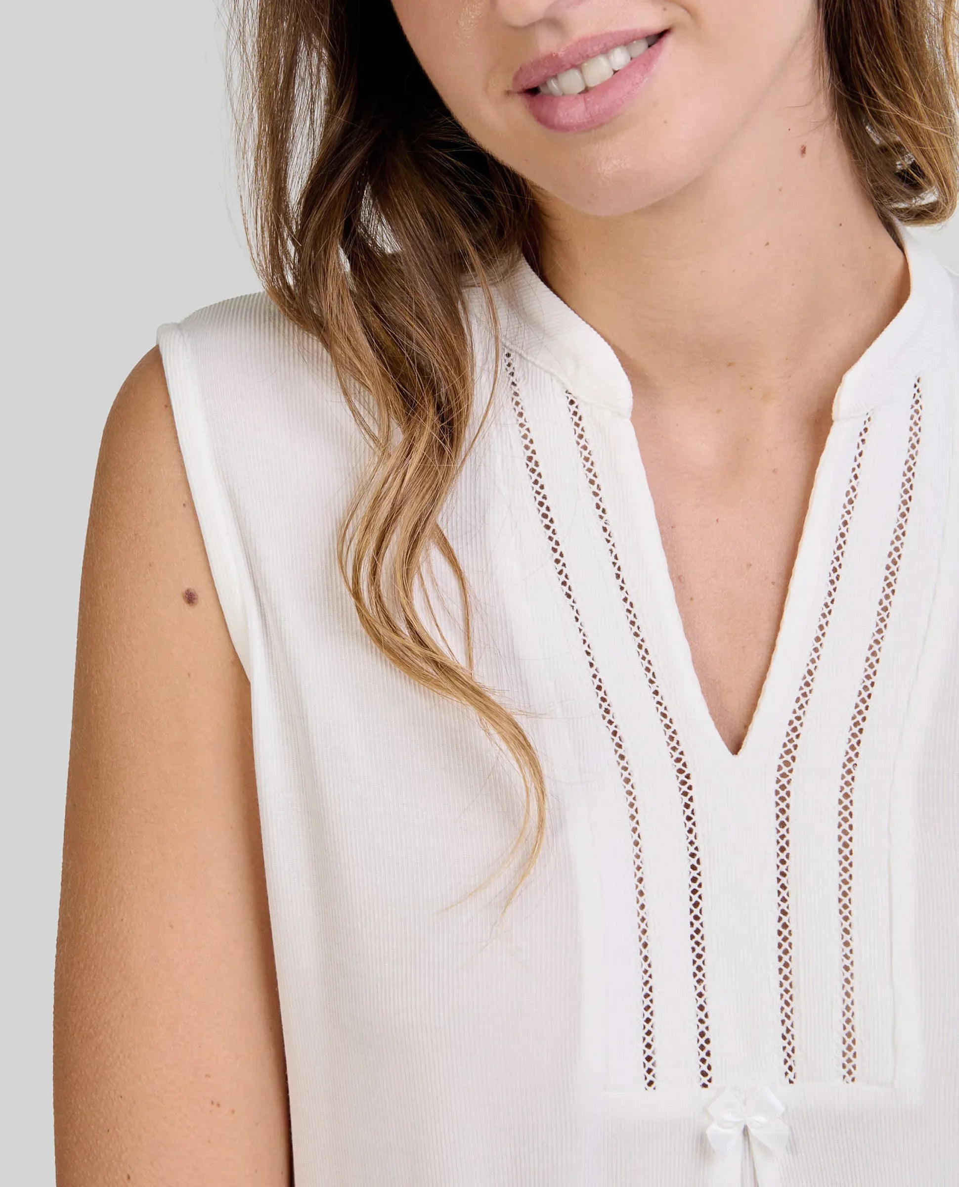 Detalle de la camisola lencera de verano rosa con cuello abierto con pata de raso y botones y encaje en cintura