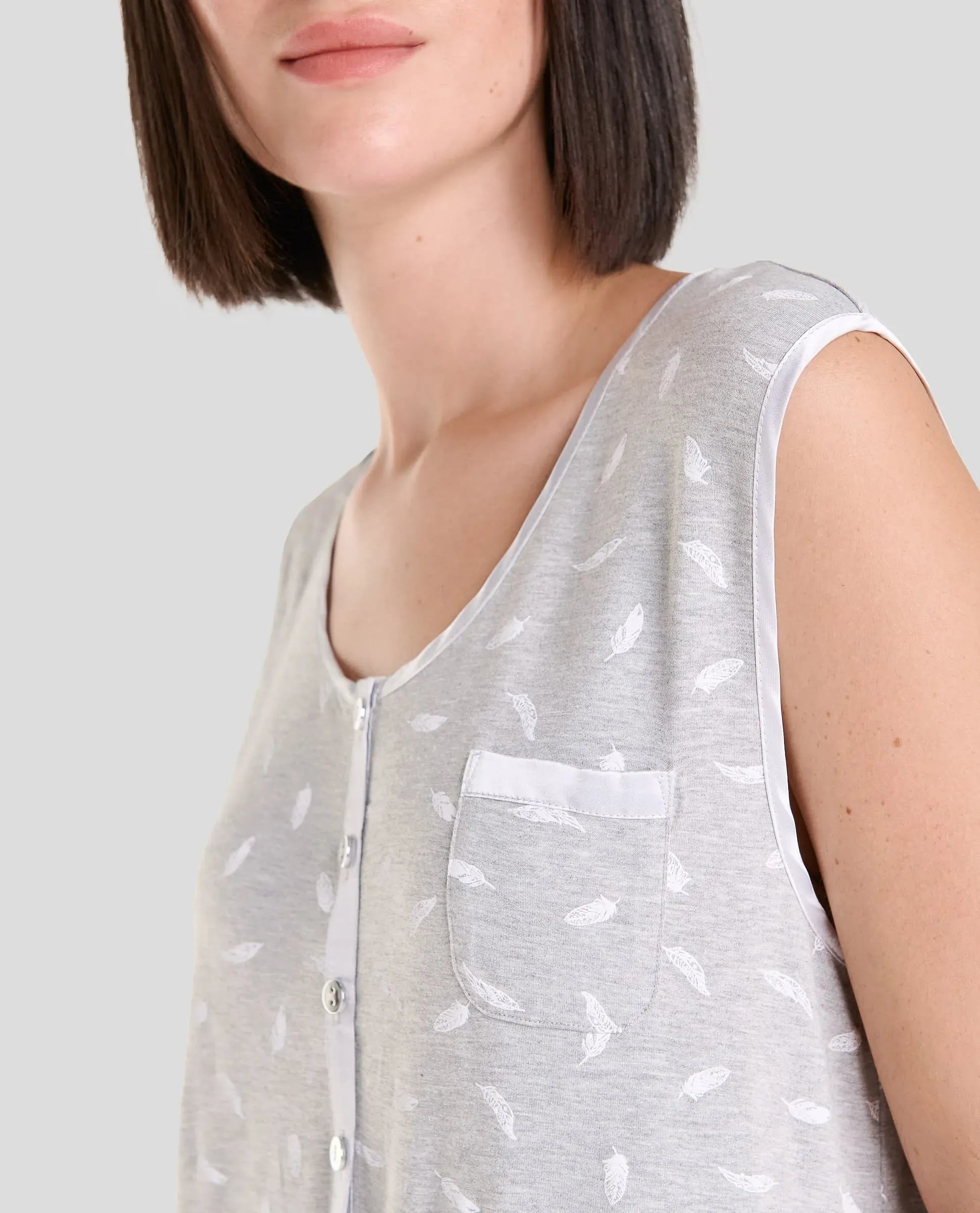 Vista detalle de camisón corto de verano sin mangas en gris estampado con cuello abierto y bolsillo decorativo