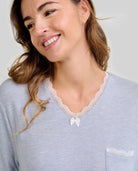 Mujer luce elegante camisón de invierno azul con encaje y lazo en el escote