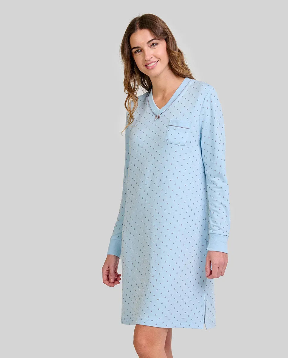 Mujer con camisón azul claro de manga larga, estampado de lunares pequeños y bolsillo