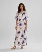 Mujer viste elegante caftan de seda natural blanco estampado de flores azules