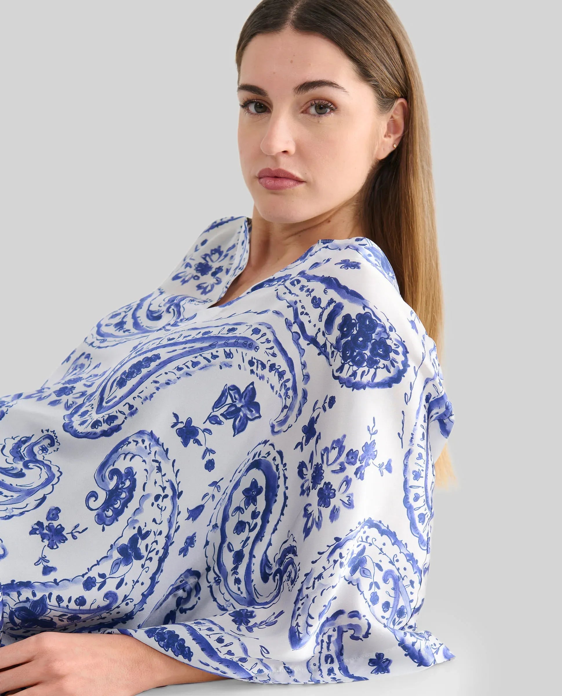 Detalle de vestido caftán blanco con estampado azul para verano y manga mariposa