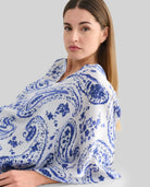 Detalle de vestido caftán blanco con estampado azul para verano y manga mariposa
