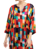 Detalle cuello abierto de kaftan de seda estampado geométrico