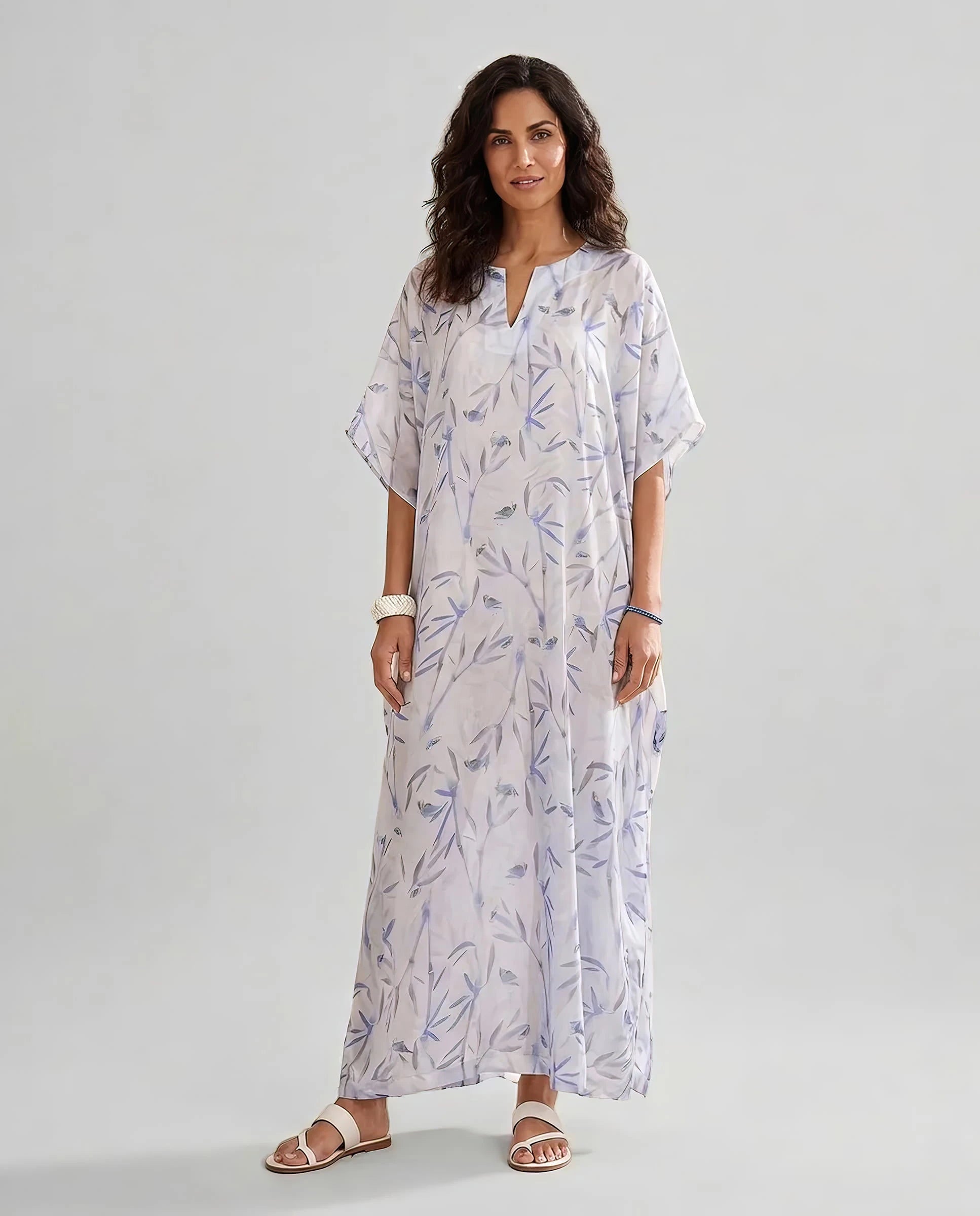 Mujer viste caftan de seda natural estampado con escote redondo y abertura central con manga mariposa al codo