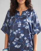 Vista detalle mujer con kaftan azul marino con estampado floral blanco y cuello en V