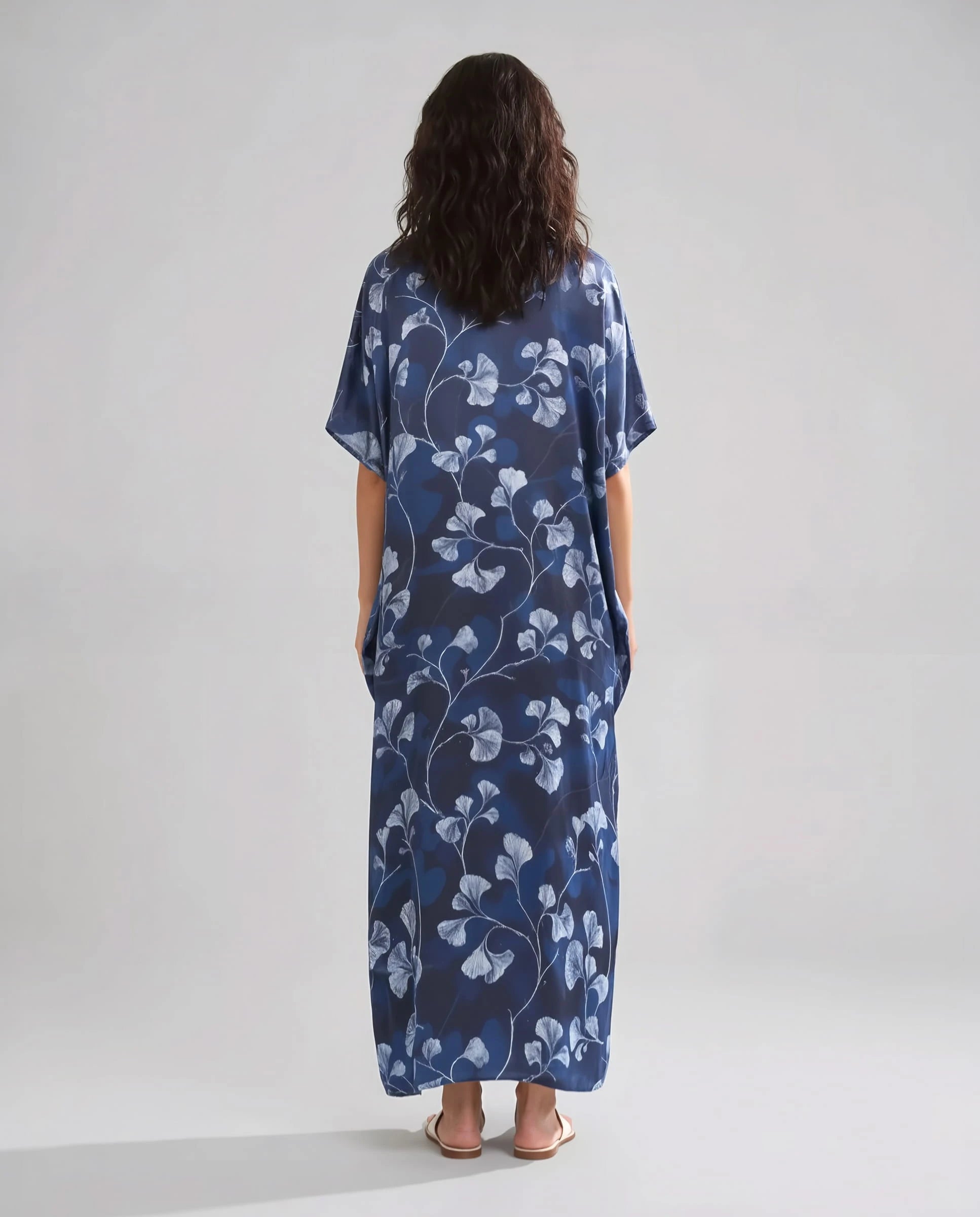 Mujer de espaldas con caftan de seda natural marino largo hasta los tobillos